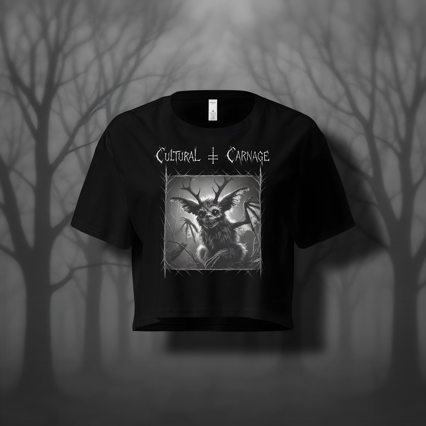 Schwarzes Gothic Crop-Top mit düsterem Backprint: Jackalope-Kreatur mit Geweih, großen Ohren und leuchtenden Augen, umgeben von Dornenrahmen und kahlen Ästen. Weißer Schriftzug "Cultural Carnage" darüber