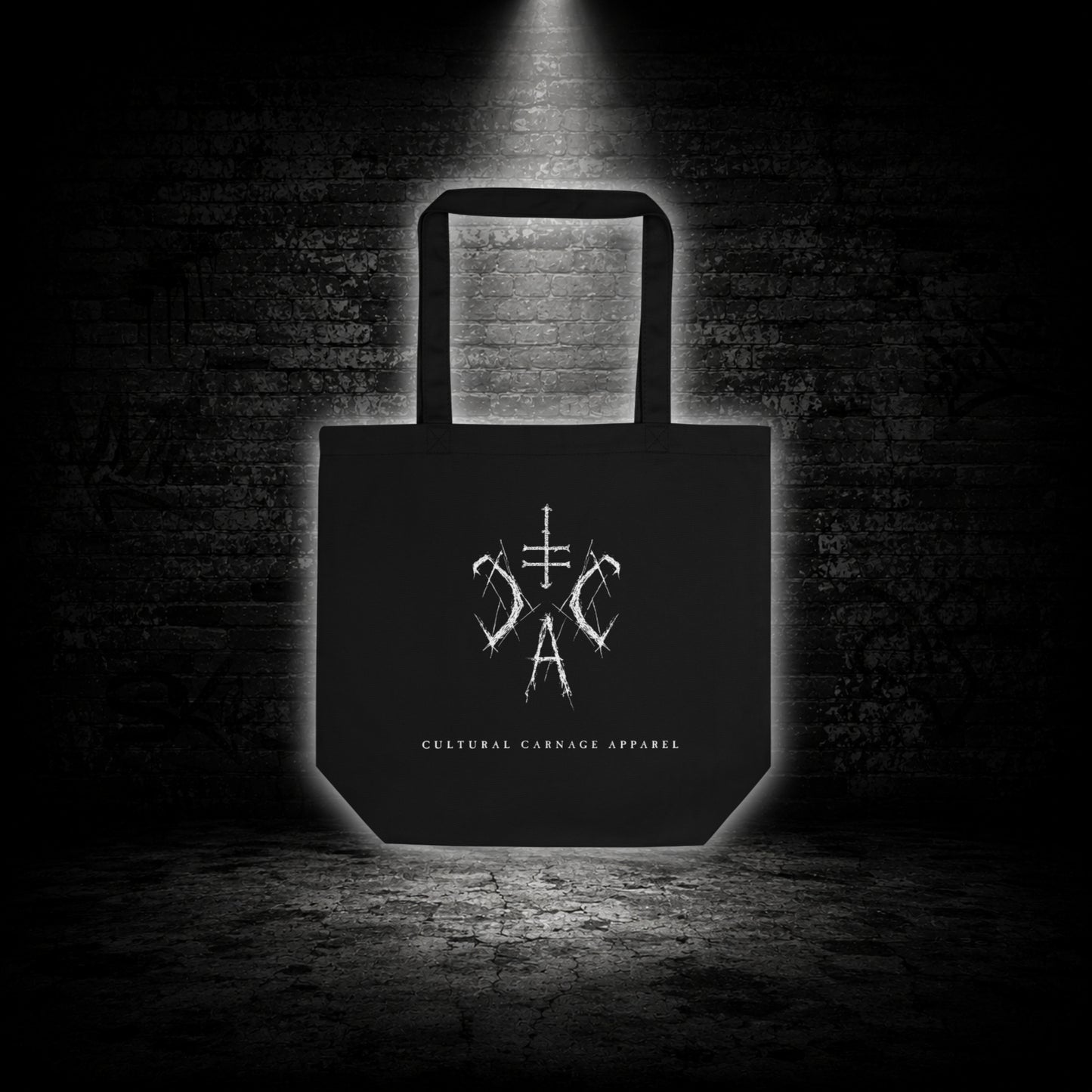 Schwarze Tote Bag mit weißem Sigil-Print und Cultural Carnage Apparel Schriftzug auf der Vorderseite im minimalistischen Alternative-Streetwear-Design.