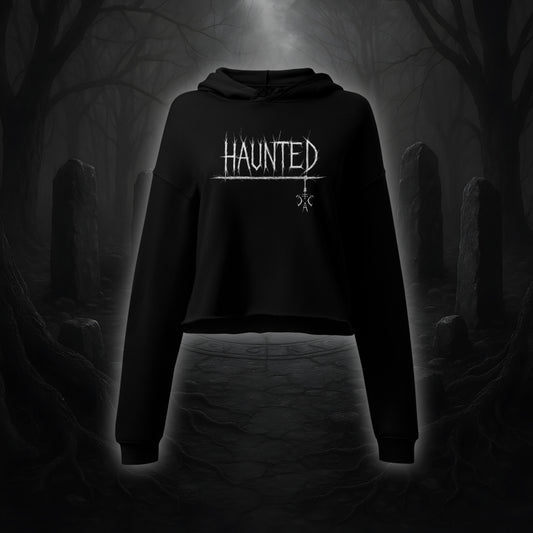 Schwarzer Crop Hoodie mit weißem Cultural Carnage Statement „HAUNTED“ im Attitude-Design