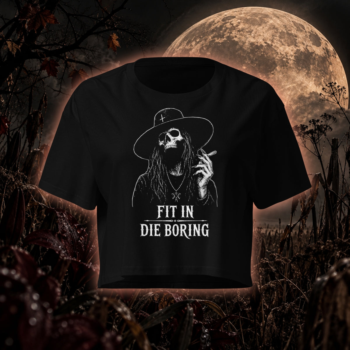 Schwarzes Crop-Top mit weißem „Fit in die Boring“-Skull- und Witch-Motiv von Cultural Carnage Apparel vor mystischer Vollmondkulisse.