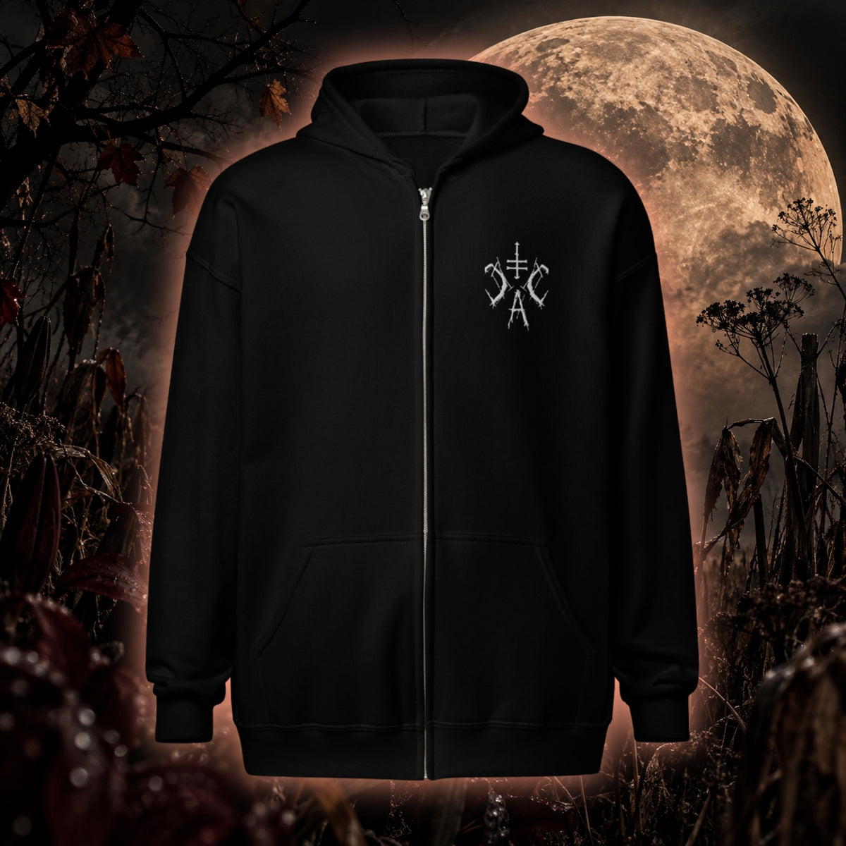Schwarzer Zip-Hoodie von Cultural Carnage Apparel mit kleinem weißem CCA-Stick auf der Brust vor düsterer herbstlicher Mondkulisse.