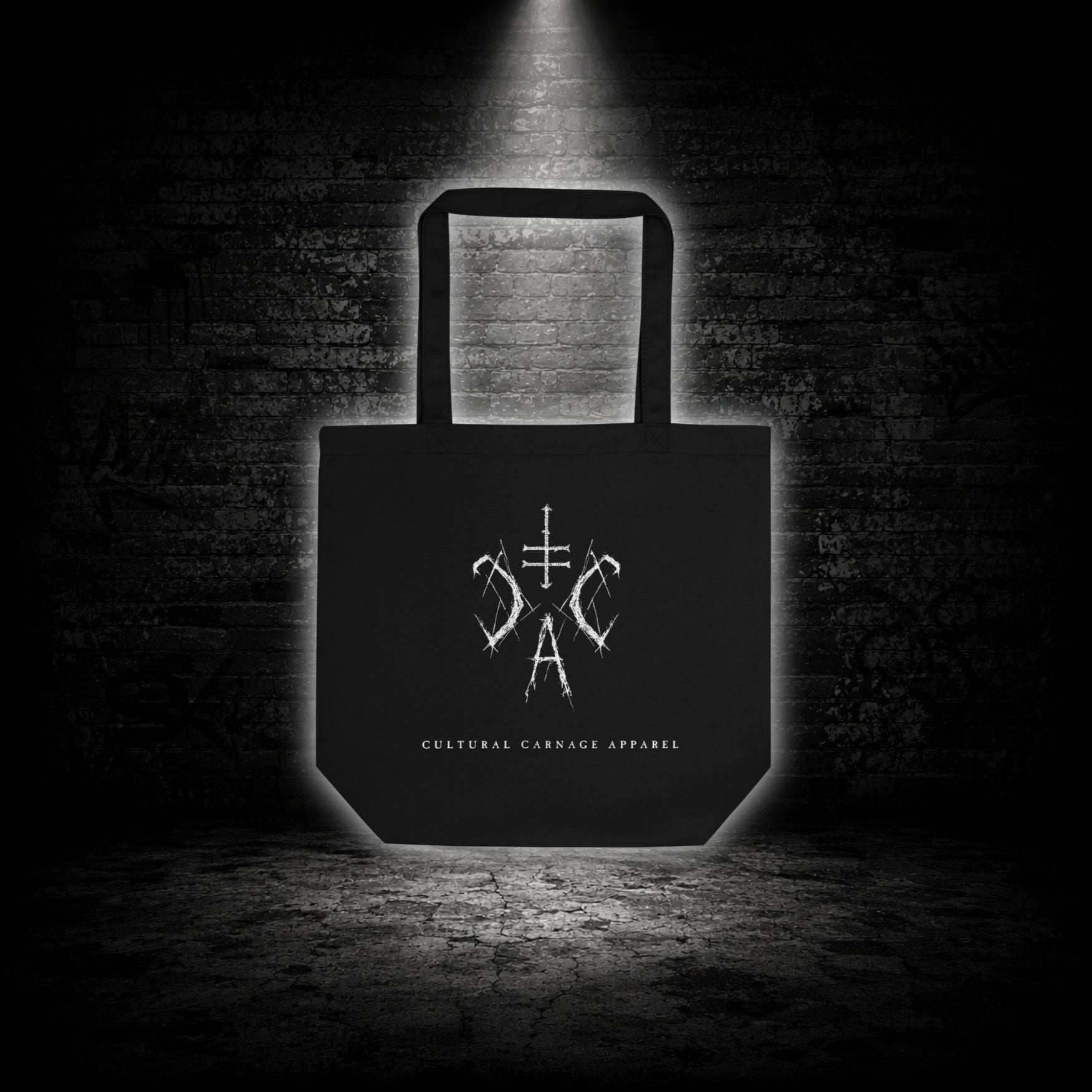 Schwarze Tote Bag mit weißem Sigil-Print und Cultural Carnage Apparel Schriftzug auf der Vorderseite im minimalistischen Alternative-Streetwear-Design.